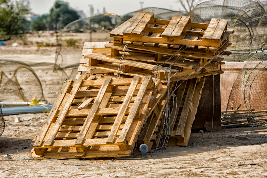 A-Hazardous-Pile-of-Wooden-Pallets-Against-a-Fence