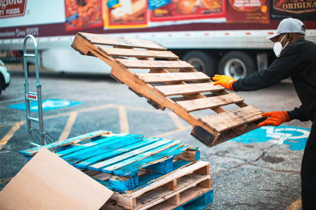 Man-Stacking-Wooden-Pallets-At-Pallet-Recycling-Center